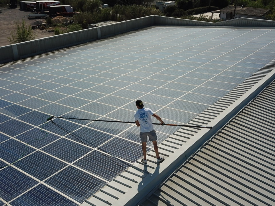 Technicien 100TRACES83 nettoyant des panneaux solaires